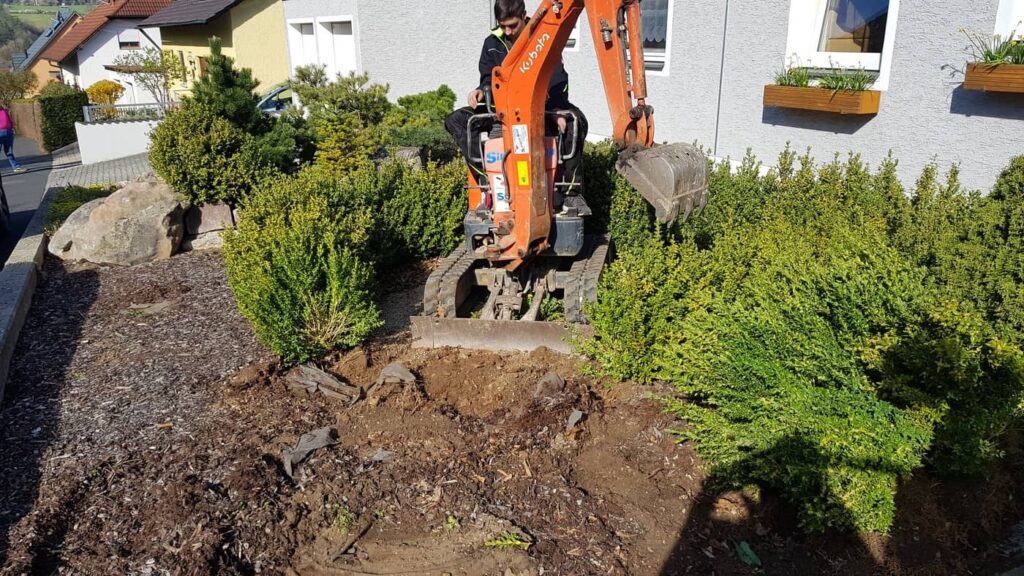 Ein Bagger beim Aushub einer Gartenfläche