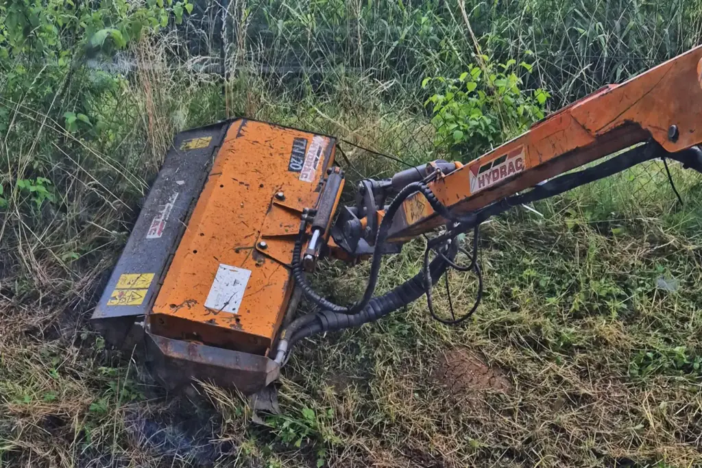 Orangnes Werkzeug für Auslegemulcharbeiten im Einsatz auf einem Damm
