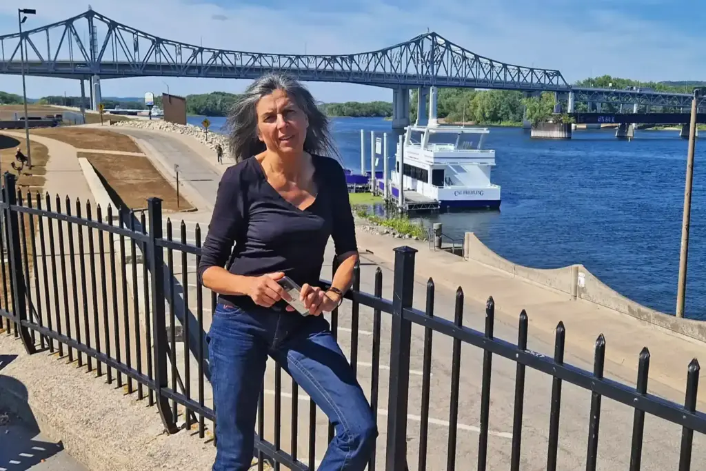 Ulli Schatz - gelehnt an ein Geländer - vor einer blauen Brücke in Amerika.
