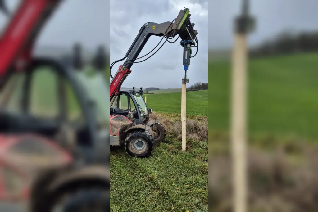 Maschineller Zaunbau mit Pfostenramme auf freiem Feld